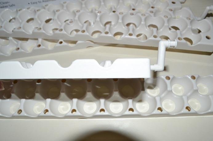 A chicken egg rail pulled out of a Little Giant turner and laid across two quail rails during the swap
