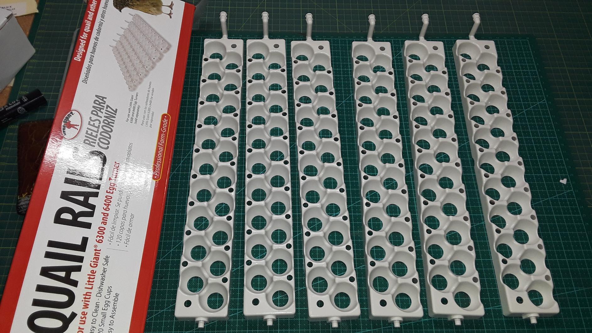 Six Little Giant 6302 quail rails laid out on a cutting mat beside the retail box